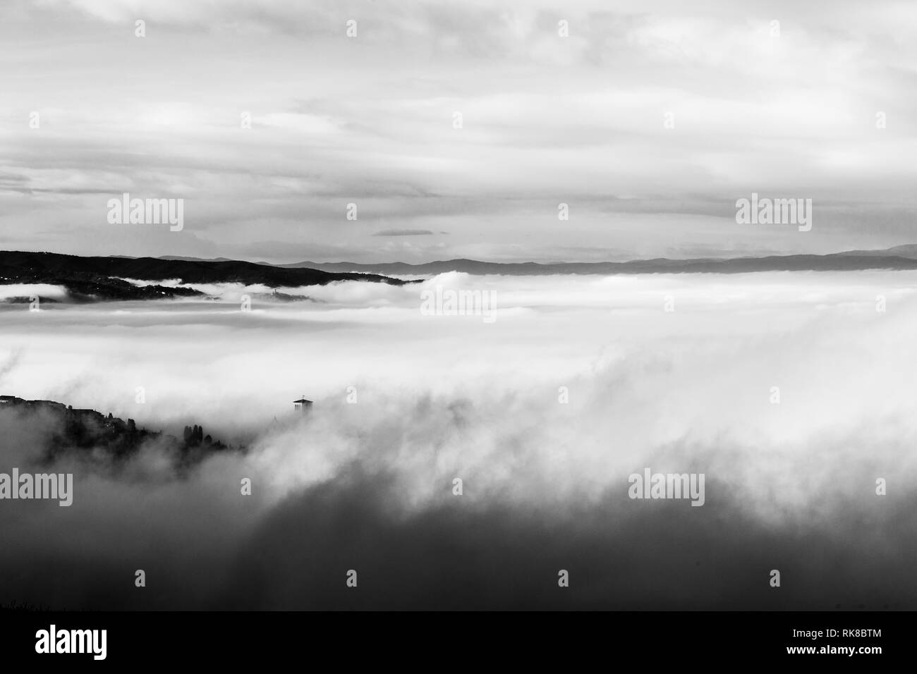 Une vue de l'église Saint-François à Assise (Ombrie, Italie) à peine visible au milieu du brouillard Banque D'Images