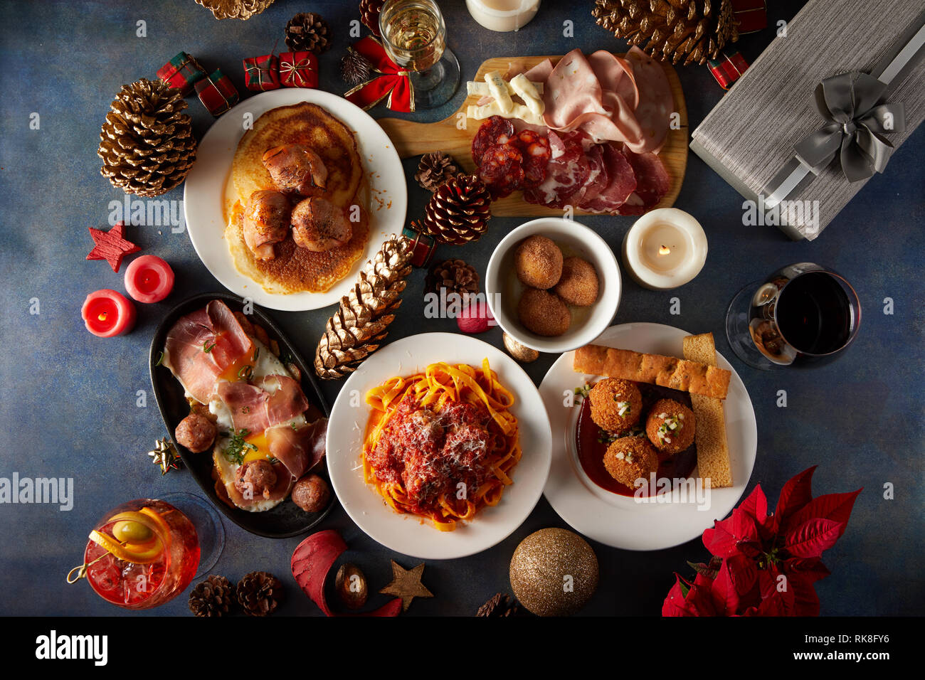 Plat d'une table de Noël avec différents types de boulettes de viande, pâtes, charcuterie et la décoration de Noël Banque D'Images