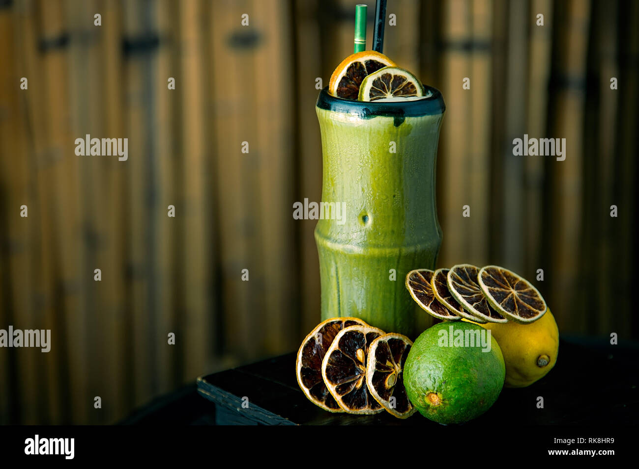 Un long cocktail rafraîchissant servi dans une tasse de bambou avec glace pilée et agrumes déshydratés Banque D'Images