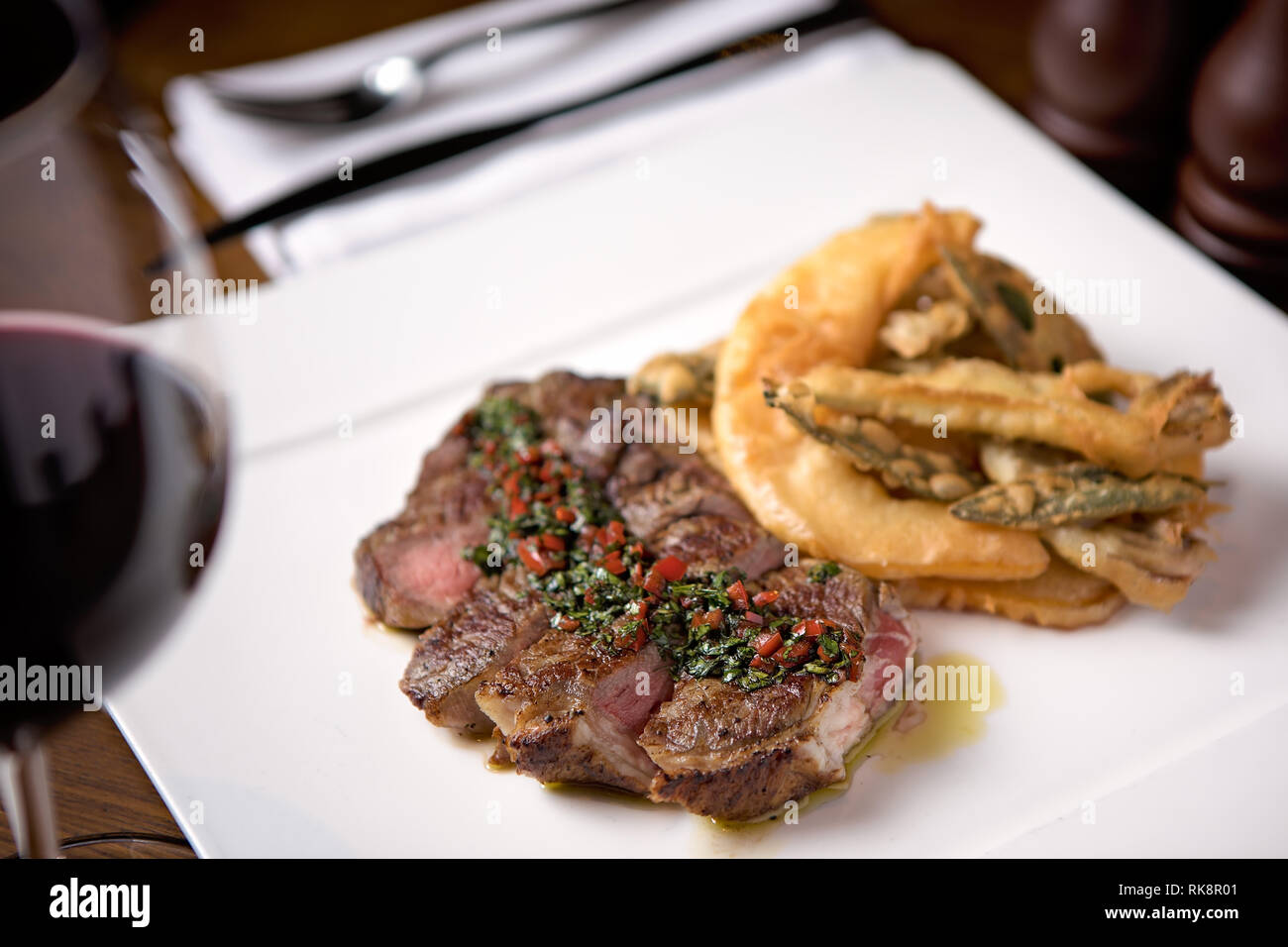 Steak juteux servi avec une sauce et quelques légumes frits Banque D'Images
