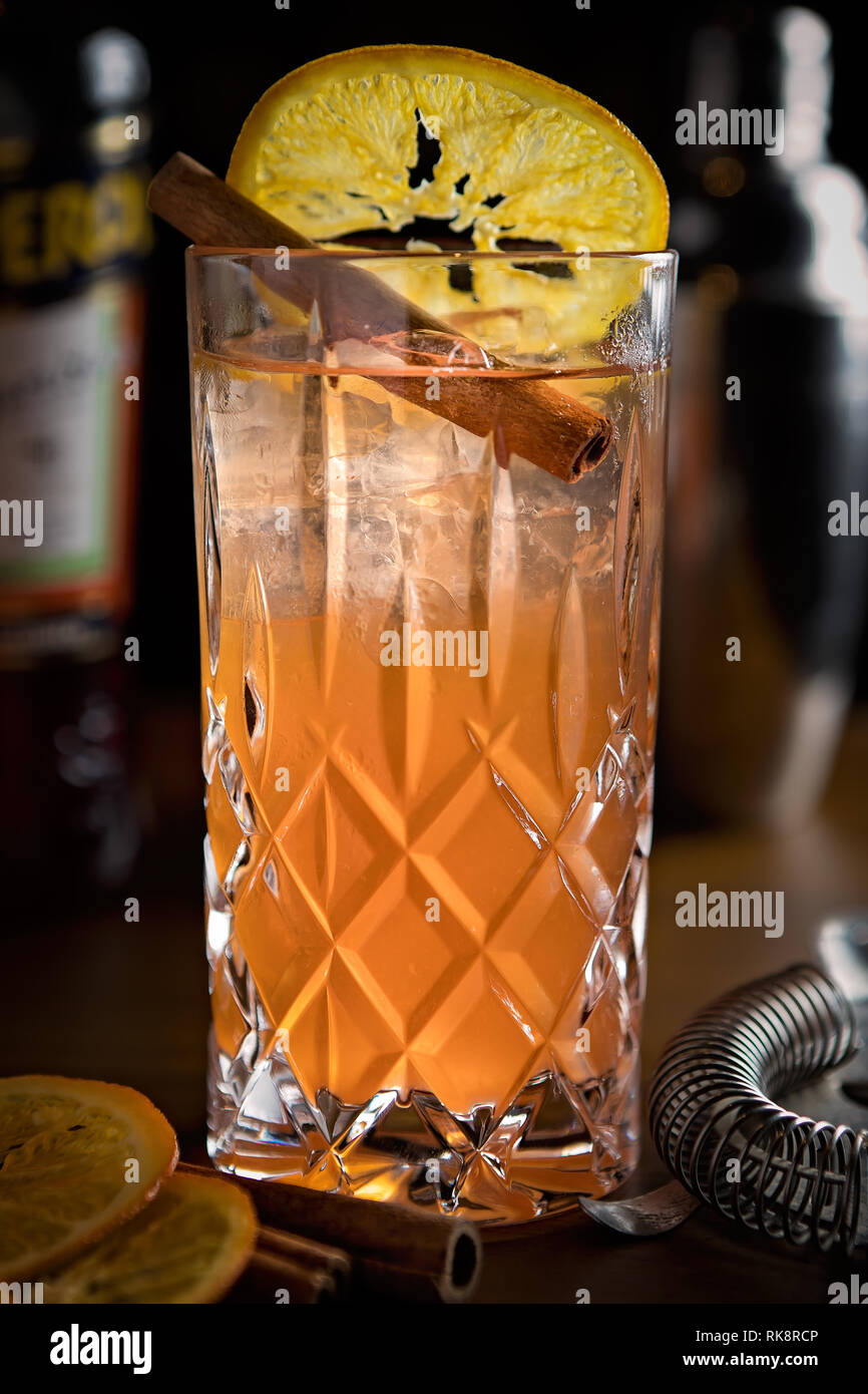 Cocktail de style apéritif long et rafraîchissant avec un bâton de cannelle servi sur glace Banque D'Images