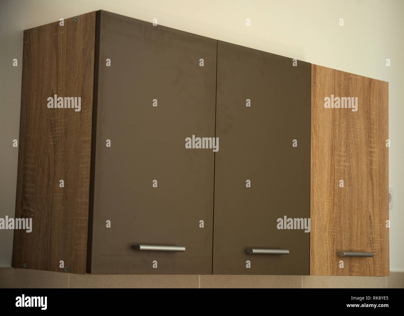 La pendaison d'armoires de cuisine sur mur blanc Banque D'Images