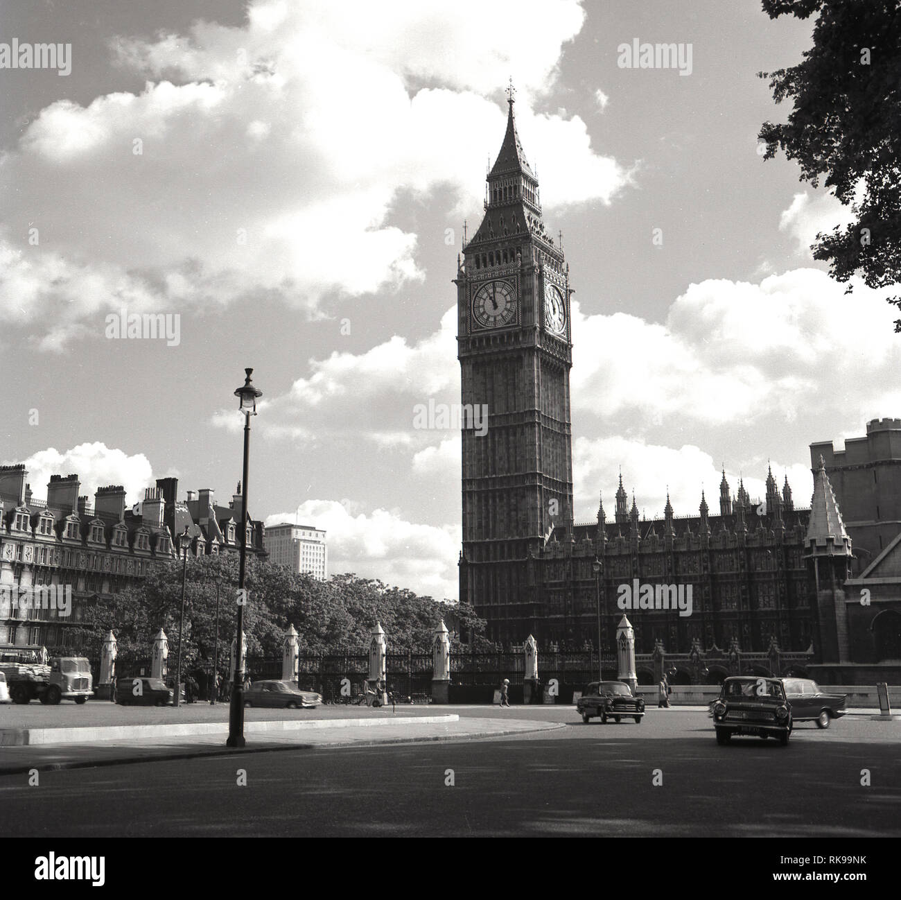 Années 1960, historiques, l'automobile passe autour de la place du Parlement à côté de l'Elizabeth ou Tour de l'horloge, il était autrefois connu, à l'extrémité nord du Palais de Westminster, la maison du gouvernement du Royaume-Uni. Conçu par Sir John Barry en 1868, la place du Parlement de Bretagne est devenu premier rond-point en 1926. La tour, également appelé 'Big Ben', a été conçue par Augustus Pugin, architecte anglais connu pour son travail dans le style néo-gothique de l'architecture et une fois achevée en 1859 a été le plus grand carillon réveil dans le monde. Banque D'Images