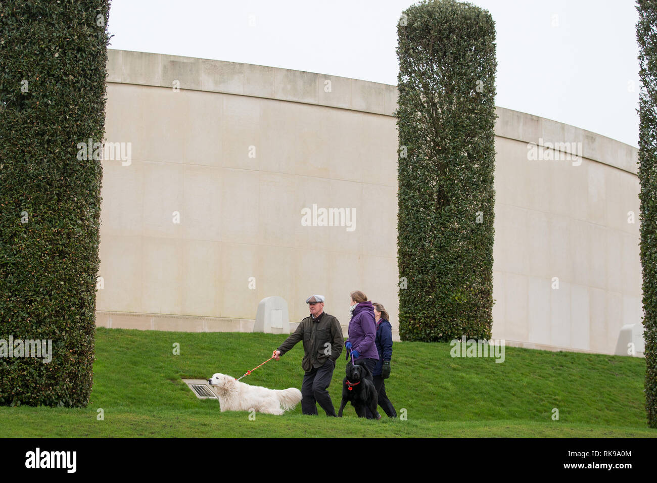 Les propriétaires de chiens devant le Mémorial des Forces armées tandis que des centaines de chiens et leurs propriétaires assistent à l'événement annuel Paws for Remembrance de l'Arboretum du Mémorial national à Alrewas, Staffordshire. Banque D'Images