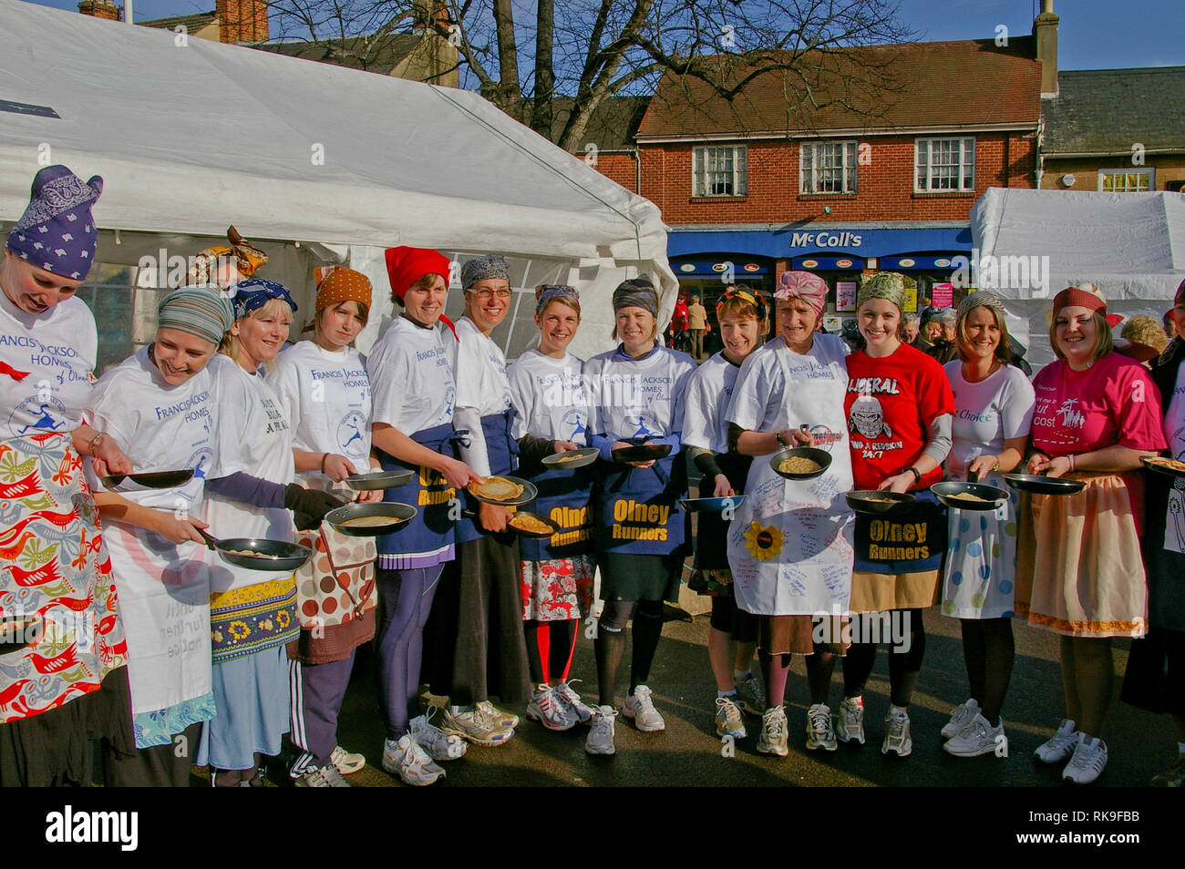 Smiling chers à la place du marché pour le début de la célèbre course de crêpes Olney, considérée comme la plus ancienne au monde, Buckinghamshire, UK Banque D'Images