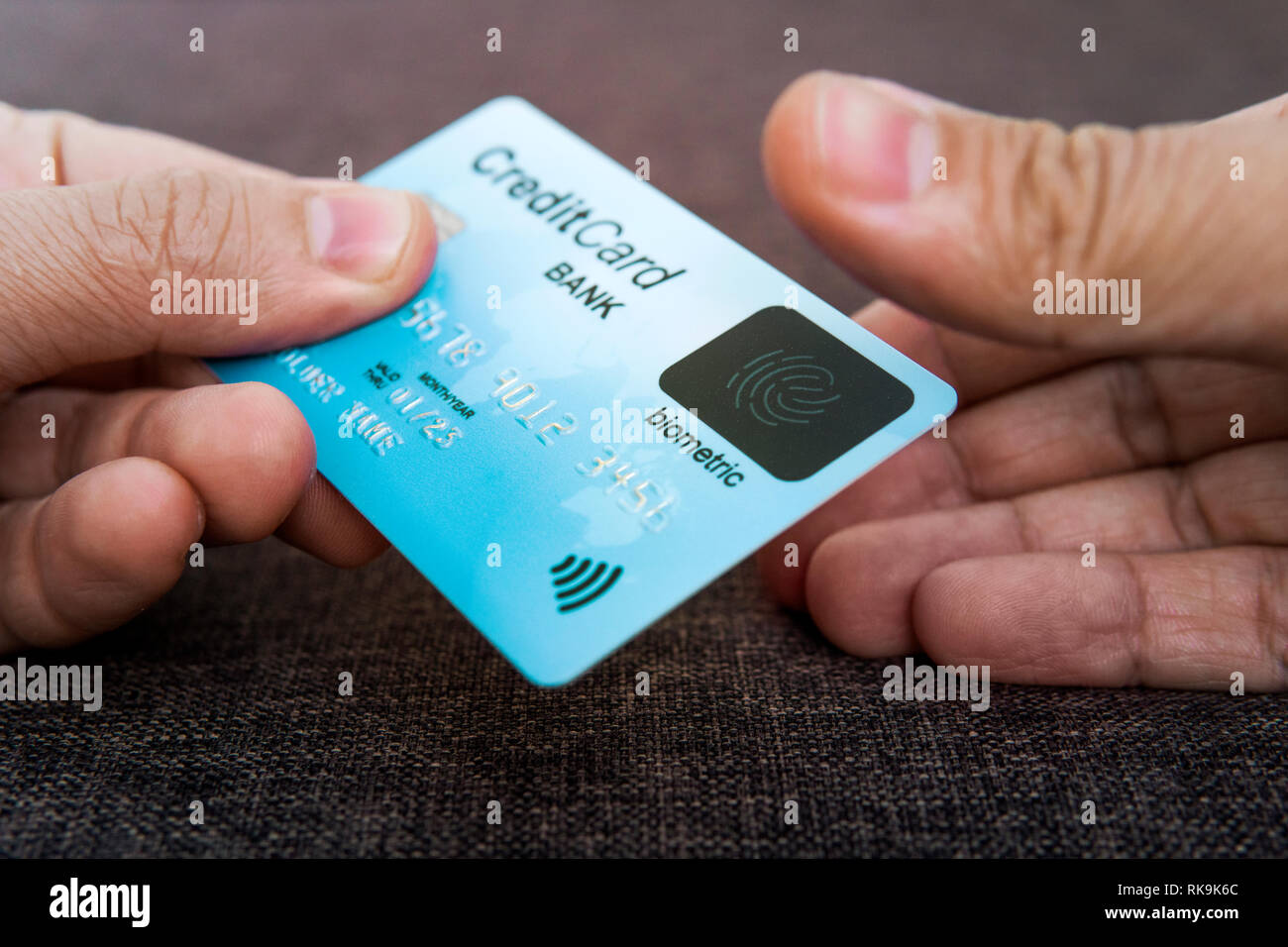 Carte de crédit a des empreintes digitales. Illustration de la sécurité de paiement biométrique. Un mâle est main tenant la carte bleue et d'autres touchant scanne Banque D'Images