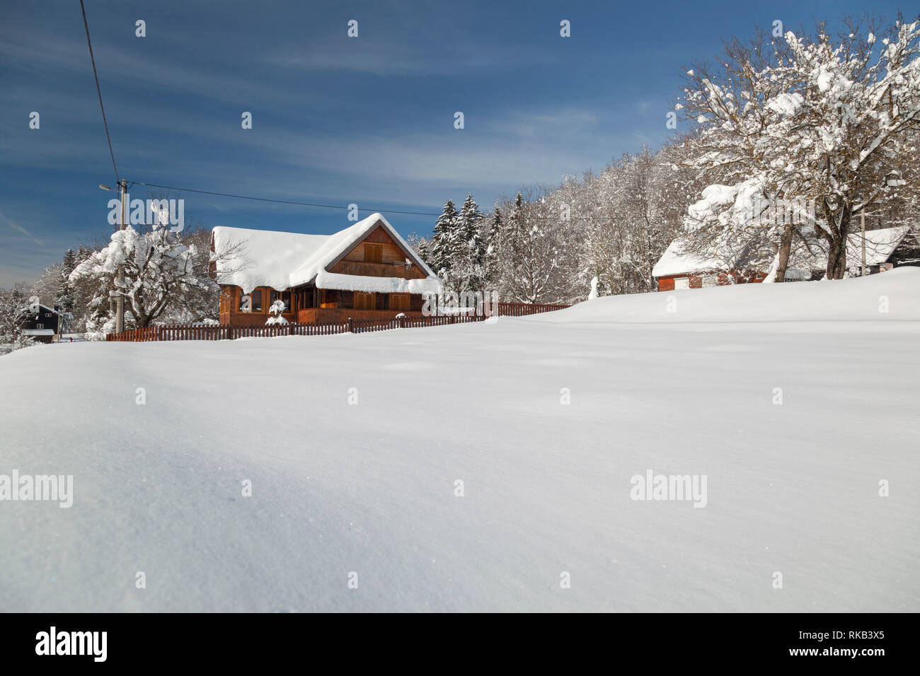 En hiver village en bois dans la région de Lika, Croatie Banque D'Images