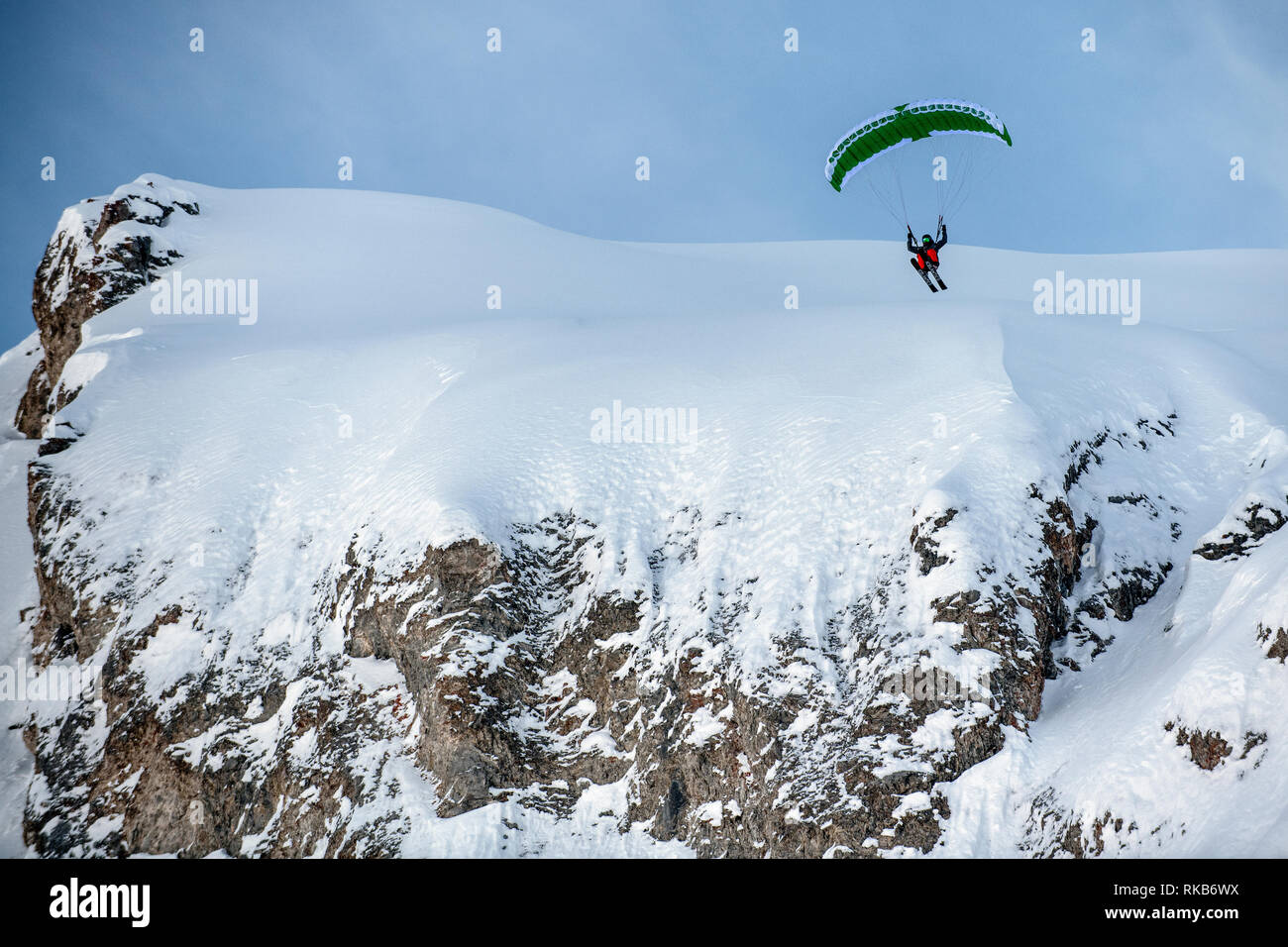 Speed-flying dans la station alpine de Courchevel. Un homme vole à l'aide d'un speed-flying wing sur des skis d'une falaise sur la neige. Banque D'Images