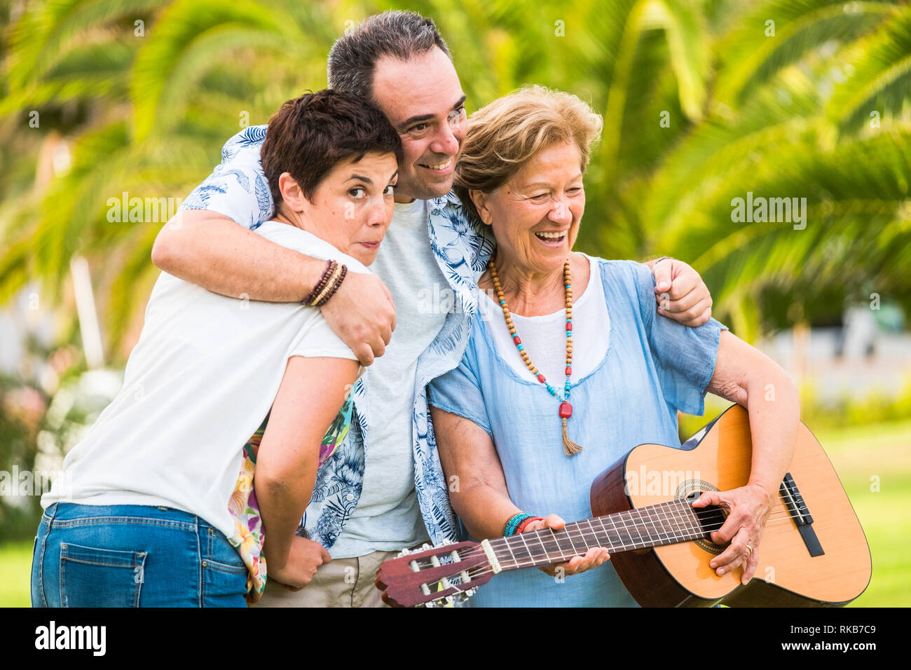 Les différents âges des générations ayant in familyh portrait activité de loisirs - vieille femme jouer une guitare et beaucoup rire - green natural ba Banque D'Images