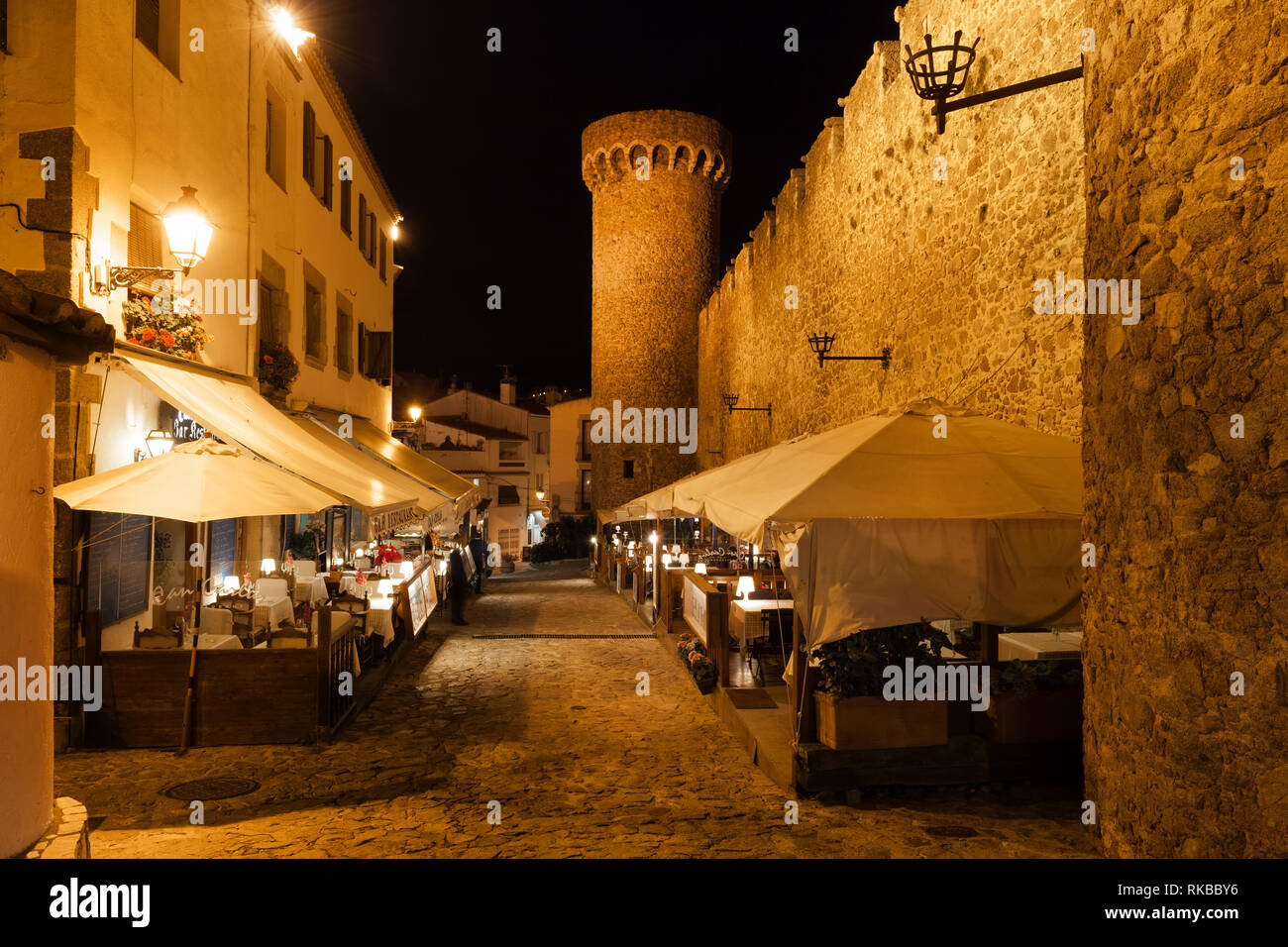 Tossa de Mar la nuit, rue pavée, avec des restaurants, des cafés à côté du mur de la vieille ville (Vila Vella), Costa Brava, Catalogne, Espagne Banque D'Images