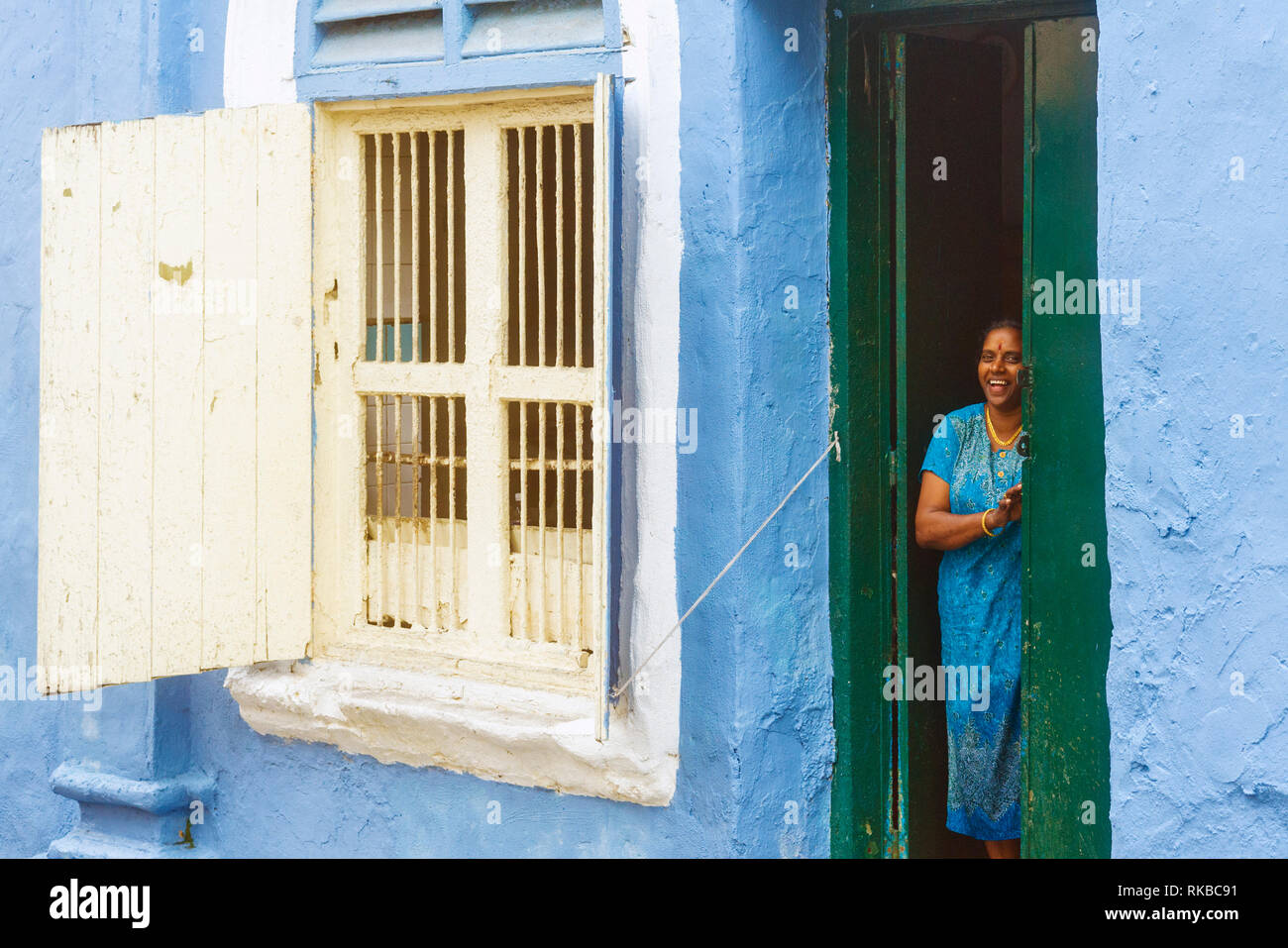 Femme à la porte de sa petite maison bleue en Inde en Ipoh, Malaisie Banque D'Images