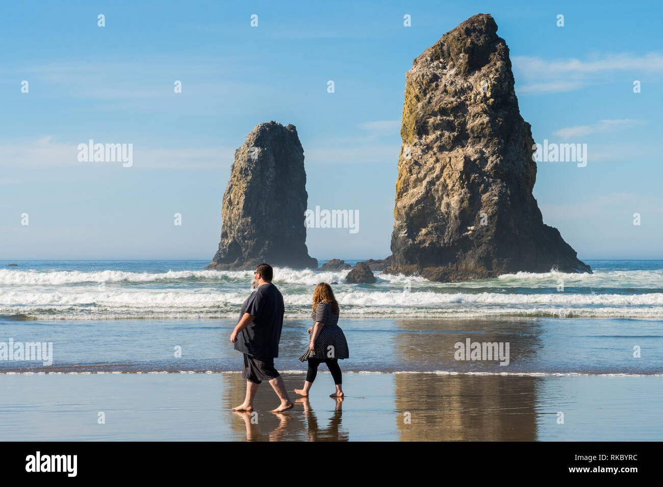 Un couple marche profitant du soleil à Cannon Beach, Oregon, USA. Banque D'Images