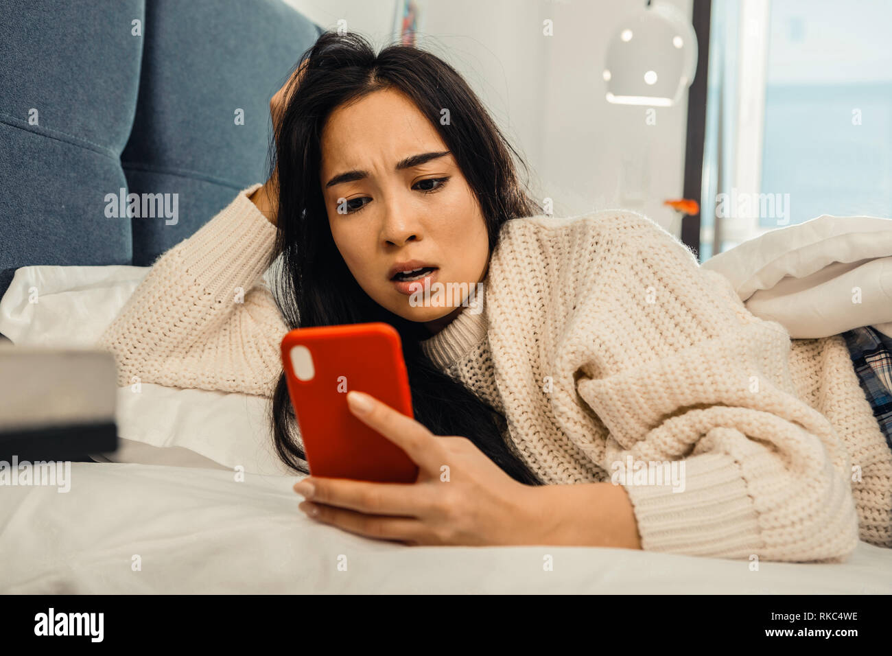Femme en colère après la lecture de message de petit ami Banque D'Images