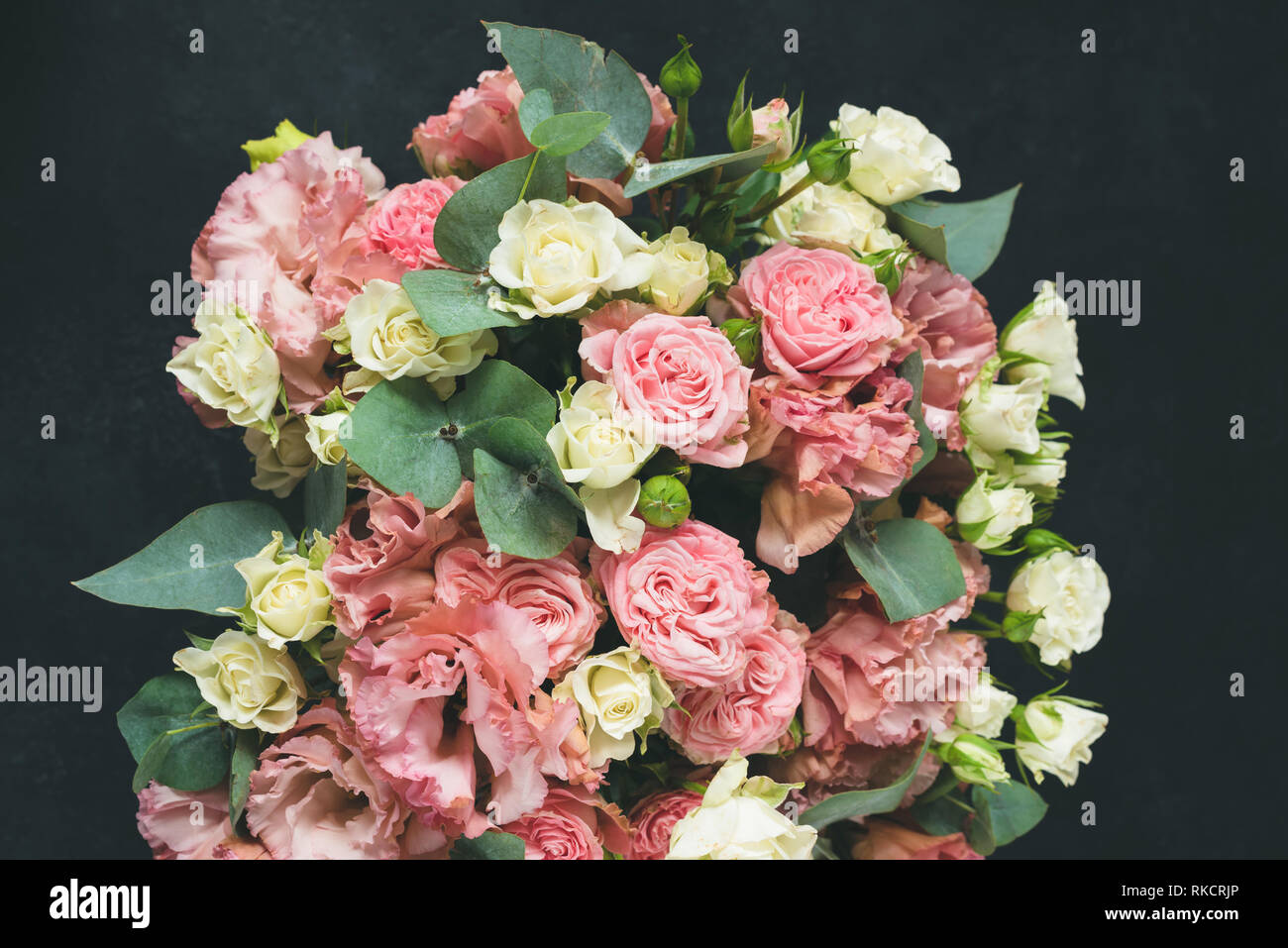 Bouquet de belles roses sur fond noir à l'Eucalyptus Banque D'Images