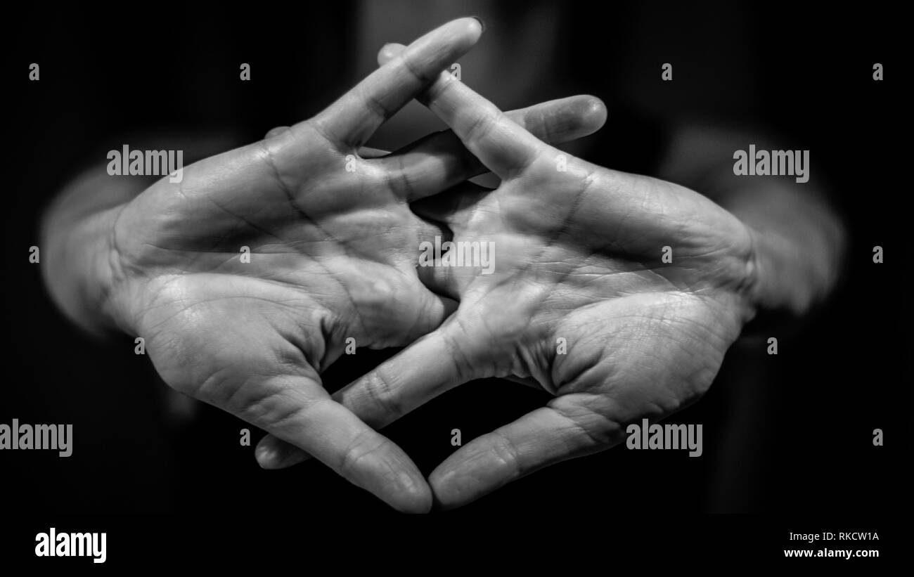 Noir et blanc photo de jeune femme étendant son corps avec ses mains à l'avant. Knuckles, yoga , sport Banque D'Images