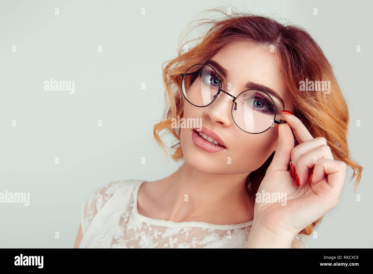 Jeune femme blonde frisée européenne holding lunettes rondes Photo Stock -  Alamy