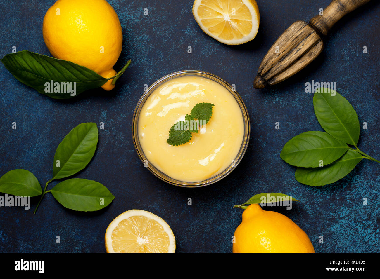Bol en verre en kurde de citron, citrons frais sur fond bleu. Vue de dessus. copy space Banque D'Images