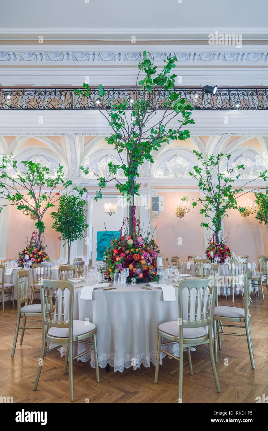 Décoration de table de mariage. Beau bouquet de fleurs sur la table, à côté des assiettes, verres en cristal et les plaques Banque D'Images