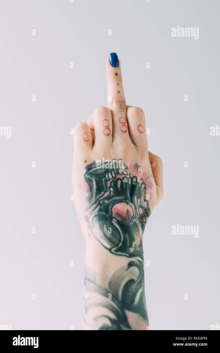 Portrait de femme avec des tatouages montrant doigt moyen isolé sur gray Banque D'Images