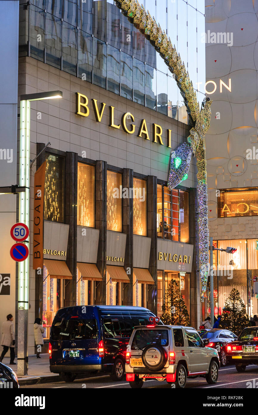 Ginza Tokyo, la nuit. Noël, le bâtiment Bvlgari avec châssis serpent lumineux géant attaché à coin. La circulation en premier plan. Banque D'Images