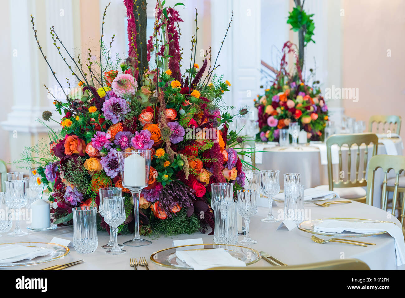 Décoration de table de mariage. Beau bouquet de fleurs sur la table, à côté  des assiettes, verres en cristal et les plaques Photo Stock - Alamy