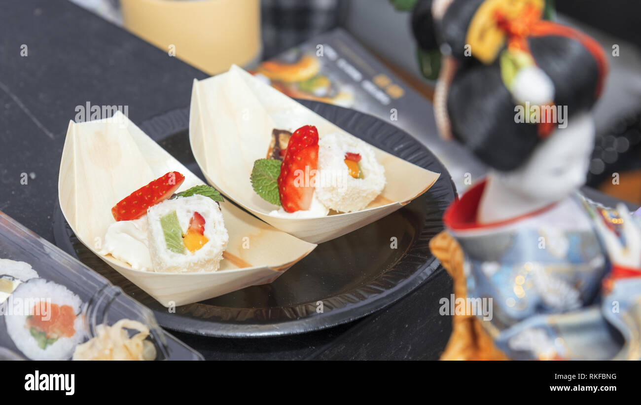 Stand avec sélection de la restauration rapide. Asian street food market. Sushis saumon et sweet style sushi, riz, mangue, fraises, kiwis, chocolat, noix de coco et Banque D'Images
