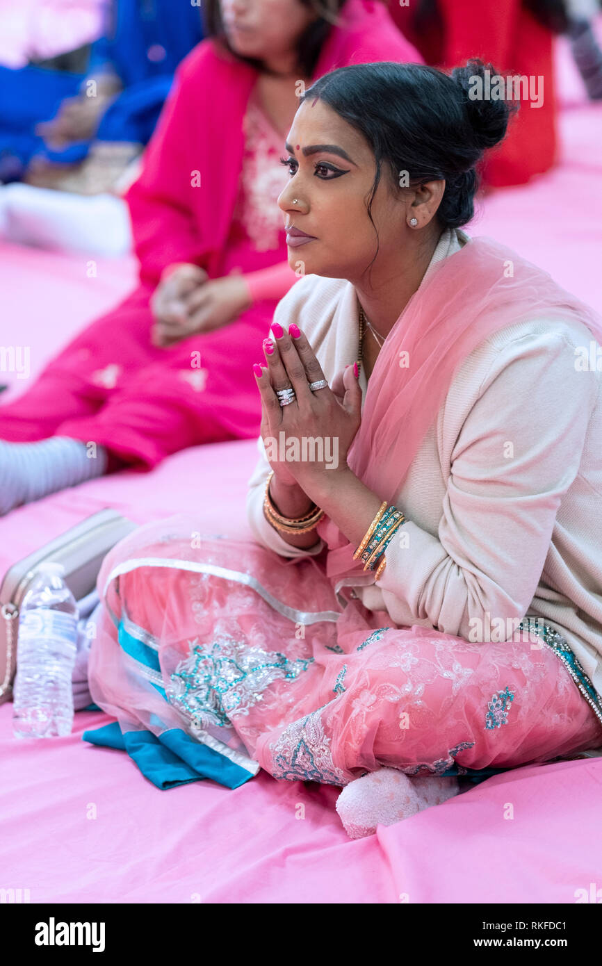Trouver une belle femme hindoue assis sur le plancher à la prière du matin à un temple hindou de la Jamaïque, Queens, New York. Banque D'Images