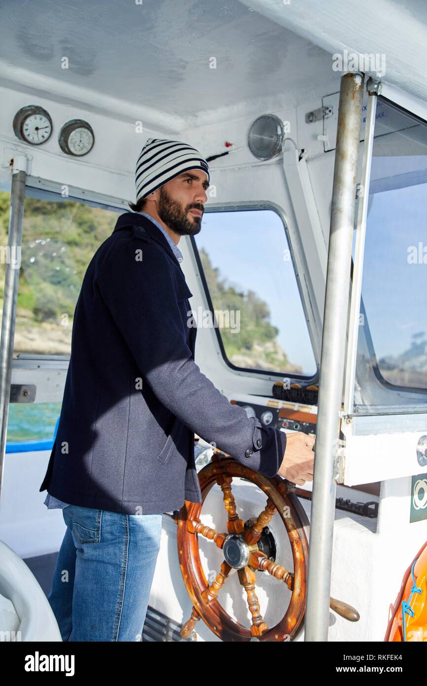 Marin, homme adulte avec gouvernail sur un bateau pour l'île de Santa Clara, Donostia, San Sebastian, Gipuzkoa, Pays Basque, Espagne, Europe Banque D'Images
