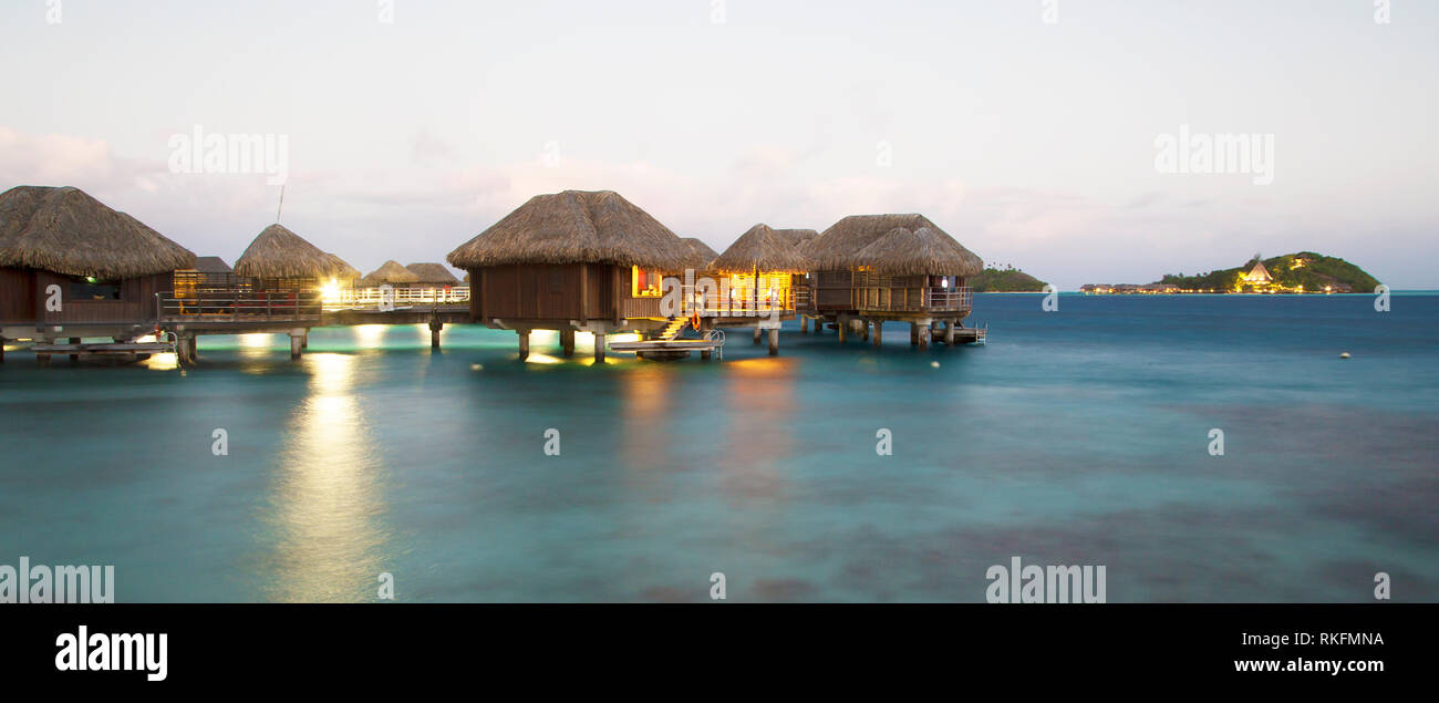 Bungalows sur pilotis au crépuscule à Bora Bora Banque D'Images