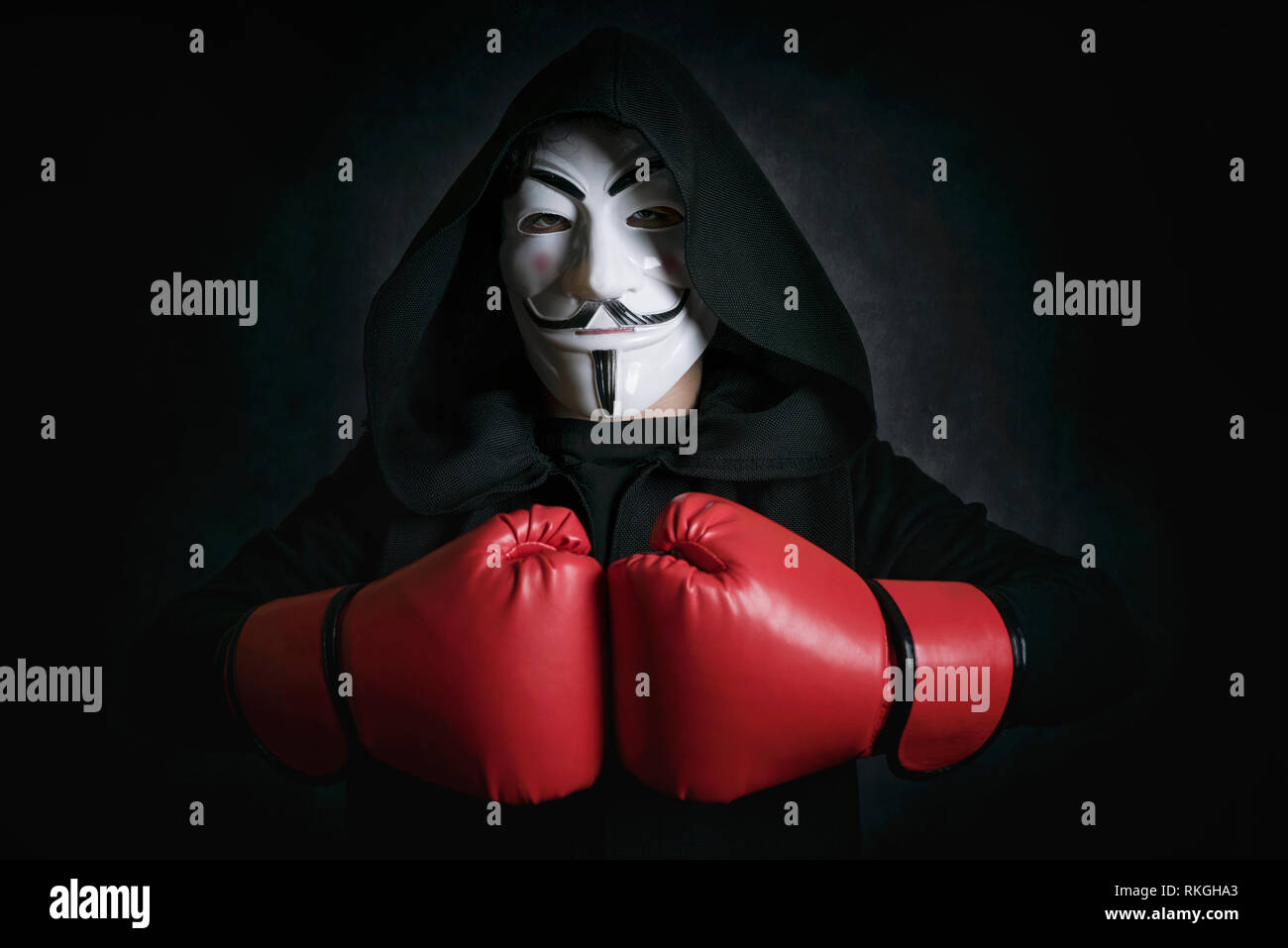 L'homme anonyme de masquage) et des gants de boxe sur fond noir Banque D'Images