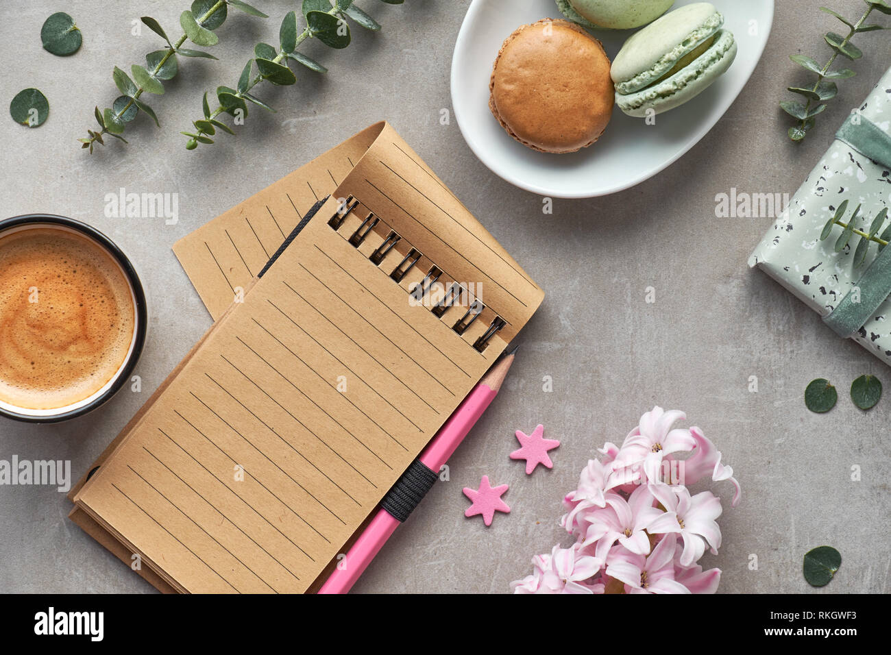 Télévision printemps pondent avec Jacinthe rose, d'eucalyptus, d'un téléphone mobile, ordinateur portable blanc, café et macarons sur pierre gris Banque D'Images