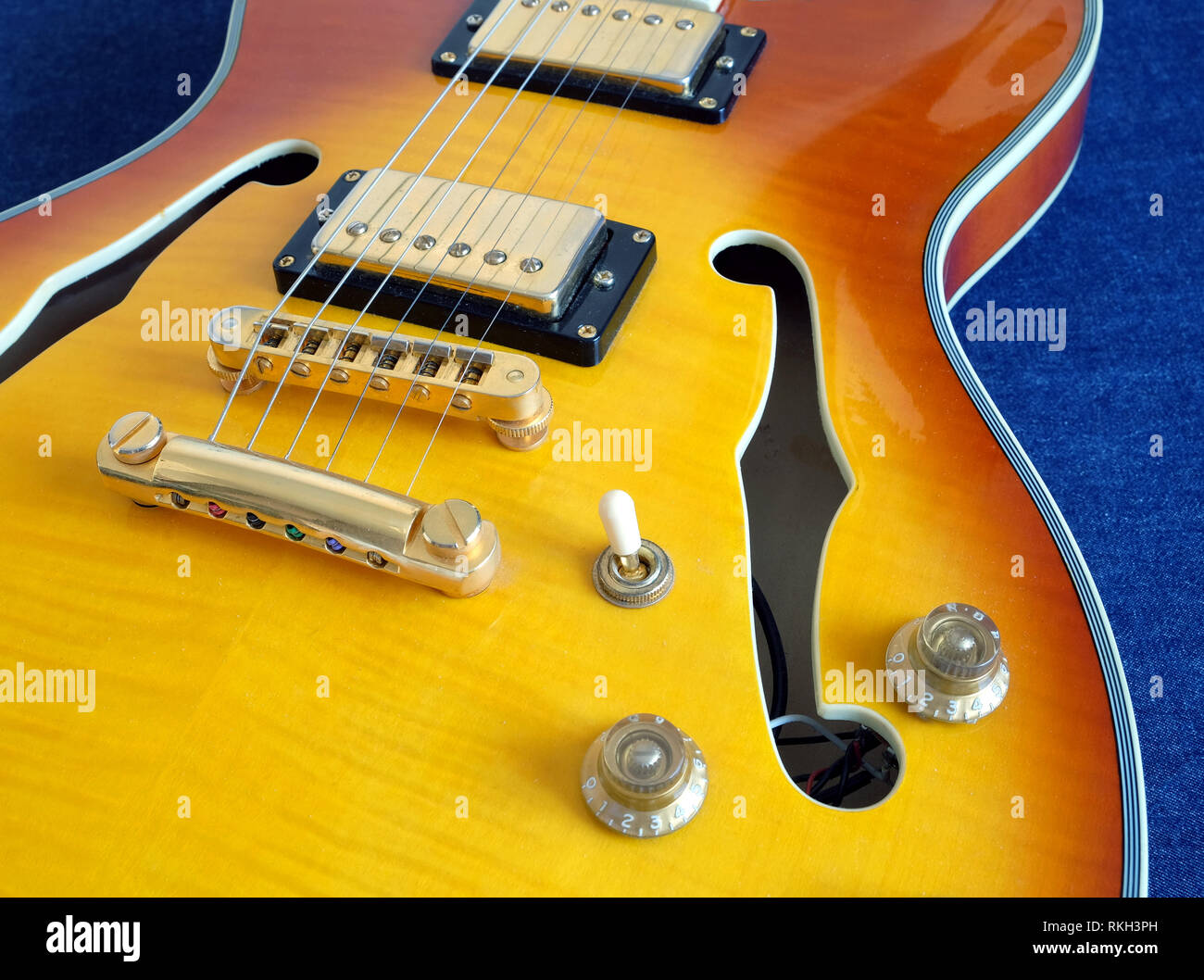 Partie de vintage semi-hollow body guitares électriques avec micros, l'électronique et des accessoires en métal boutons jeans sur gros plan l'arrière-plan Banque D'Images