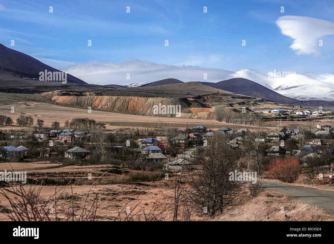 Vue d'hiver ensoleillée, ciel bleu avec plus d'un petit village,dans la plaine couverte de neige et de montagnes couvertes de brouillard Aragats Banque D'Images