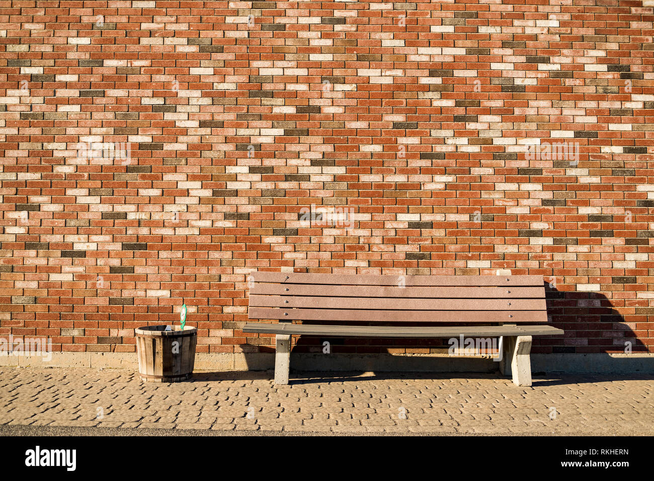 Banc en bois et un mur de brique rouge contexte Banque D'Images