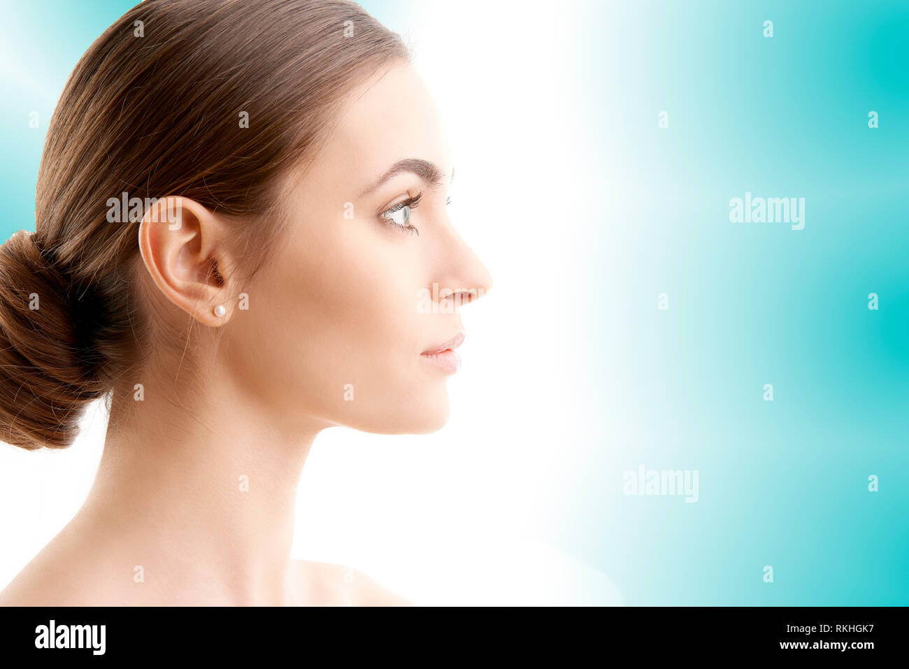 Profil femme shot. Belle jeune femme avec une peau parfaite à la voiture tandis que debout à la lumière isolée sur fond bleu. Banque D'Images