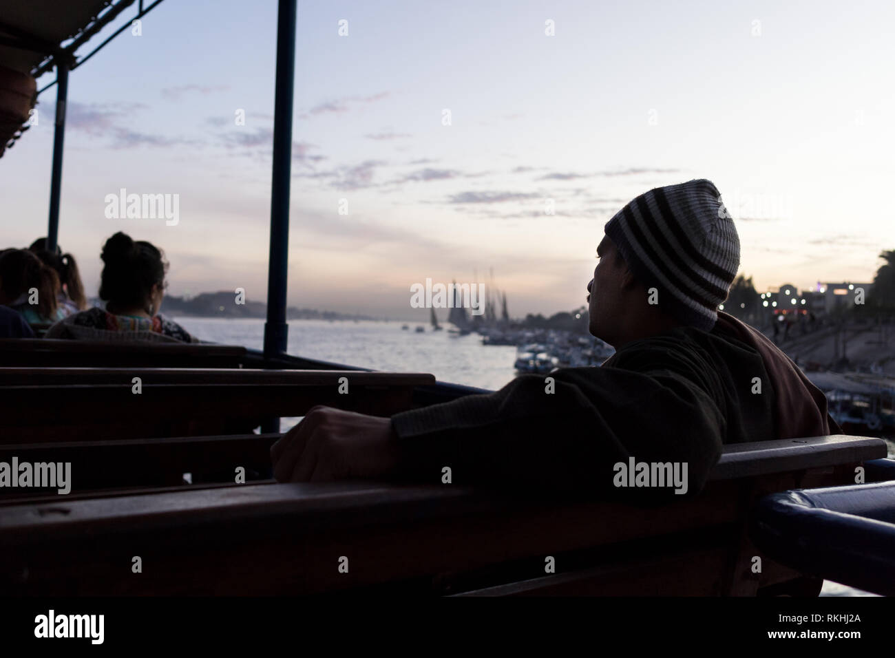 Un homme est assis sur le Luxor, Egypte, train qui traverse le Nil Banque D'Images