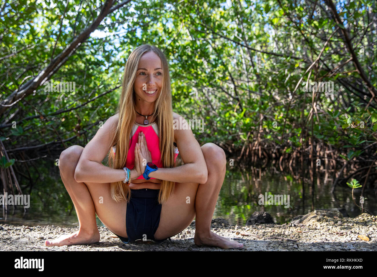 Young woman practicing yoga (Garland poser - Malasana) dans un cadre naturel - Fort Lauderdale, Floride, USA Banque D'Images