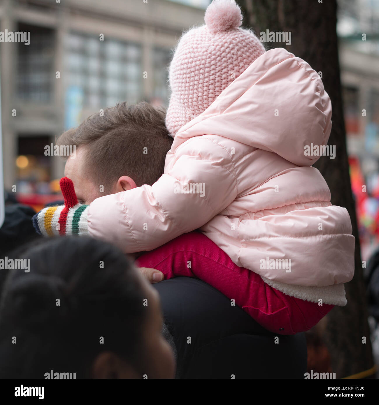 Un jeune enfant se trouve au-dessus de l'épaule d'un homme pour obtenir une meilleure vue de la parade du Nouvel An chinois 2019 Banque D'Images