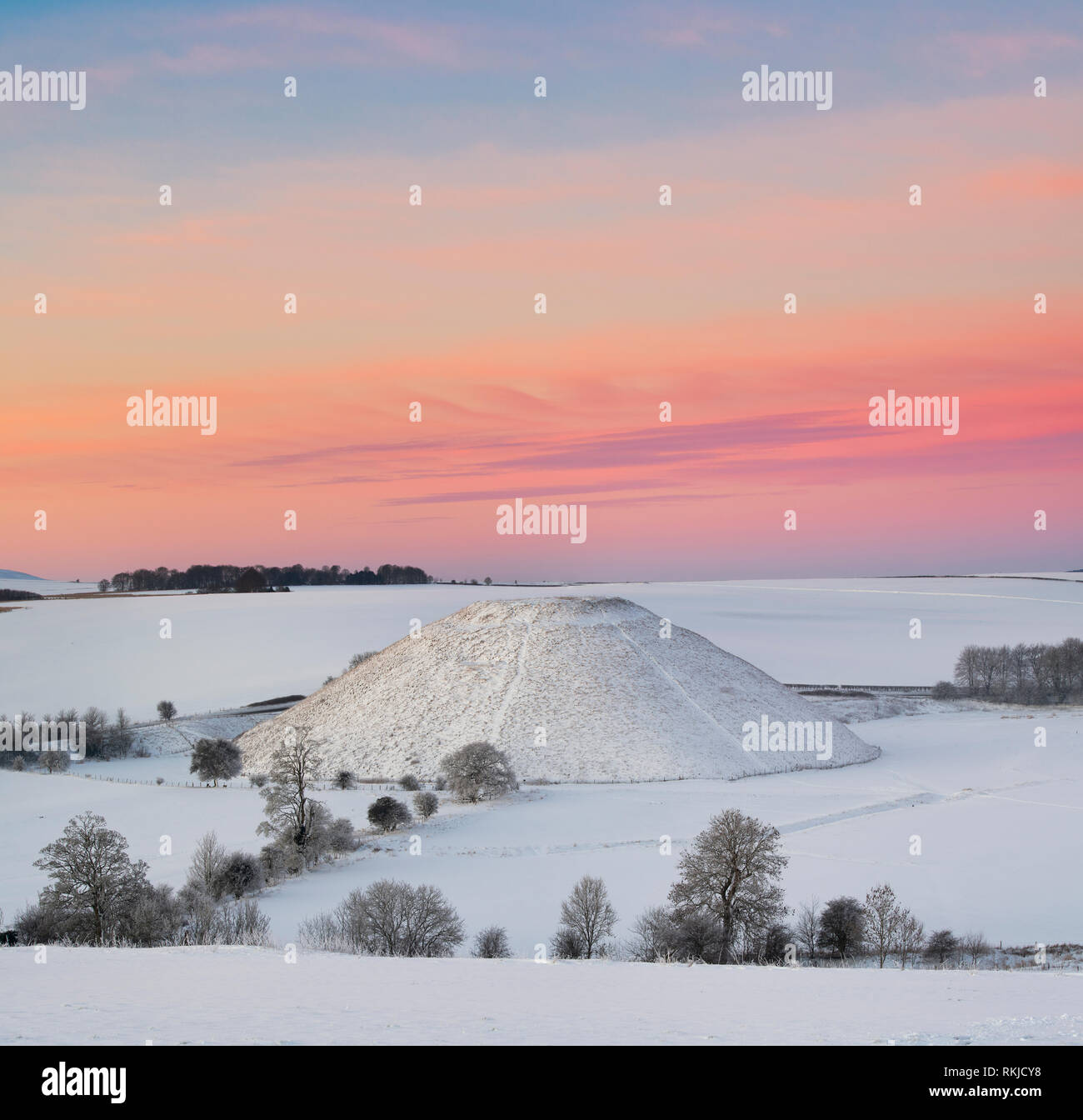 Silbury Hill dans la neige de l'hiver au crépuscule avant le lever du soleil. Avebury, dans le Wiltshire, Angleterre Banque D'Images