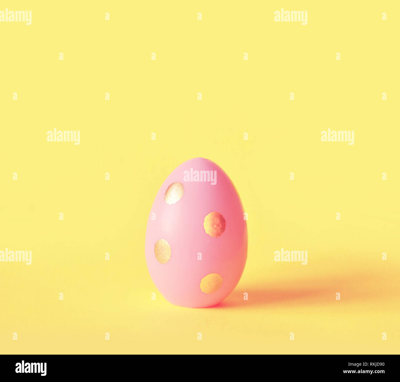 Œuf de Pâques sur fond jaune pastel. Joyeuses Pâques concept. Concept minimal Banque D'Images