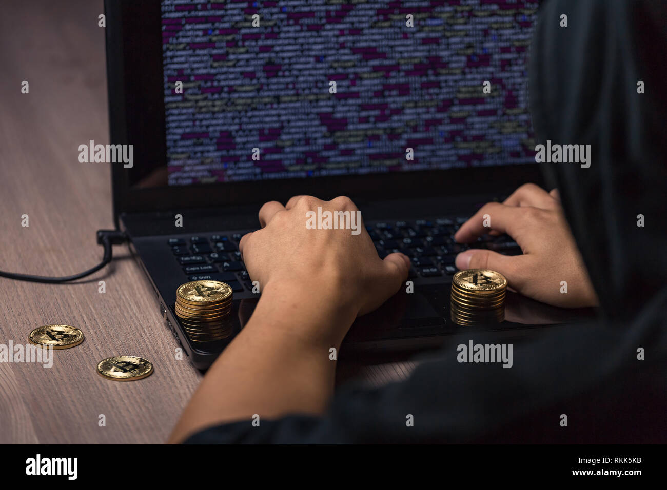 Hacker à capuchon dangereux sur l'ordinateur portable se casse la sécurité informatique sistem et voler des cryptocurrency bitcoin Banque D'Images