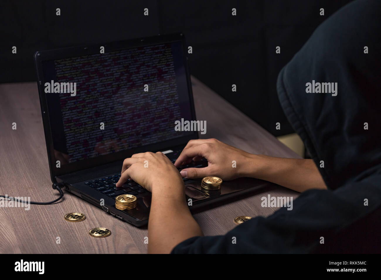 Hacker à capuchon dangereux sur l'ordinateur portable se casse la sécurité informatique sistem et voler des cryptocurrency bitcoin Banque D'Images