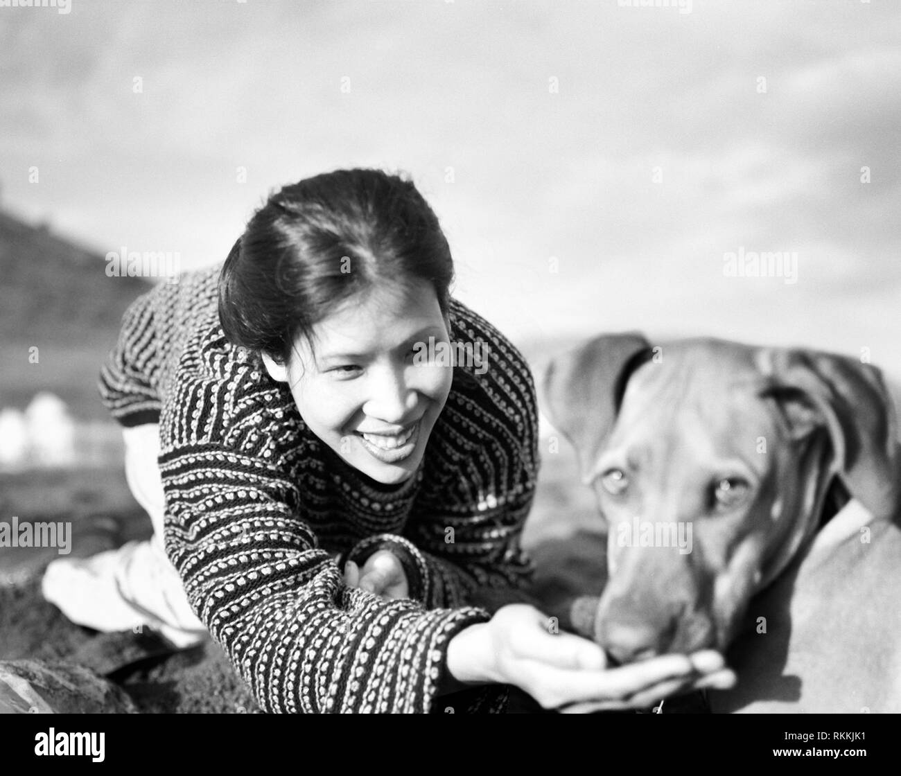 Mid-adult woman playing heureusement avec chien à l'extérieur. Banque D'Images