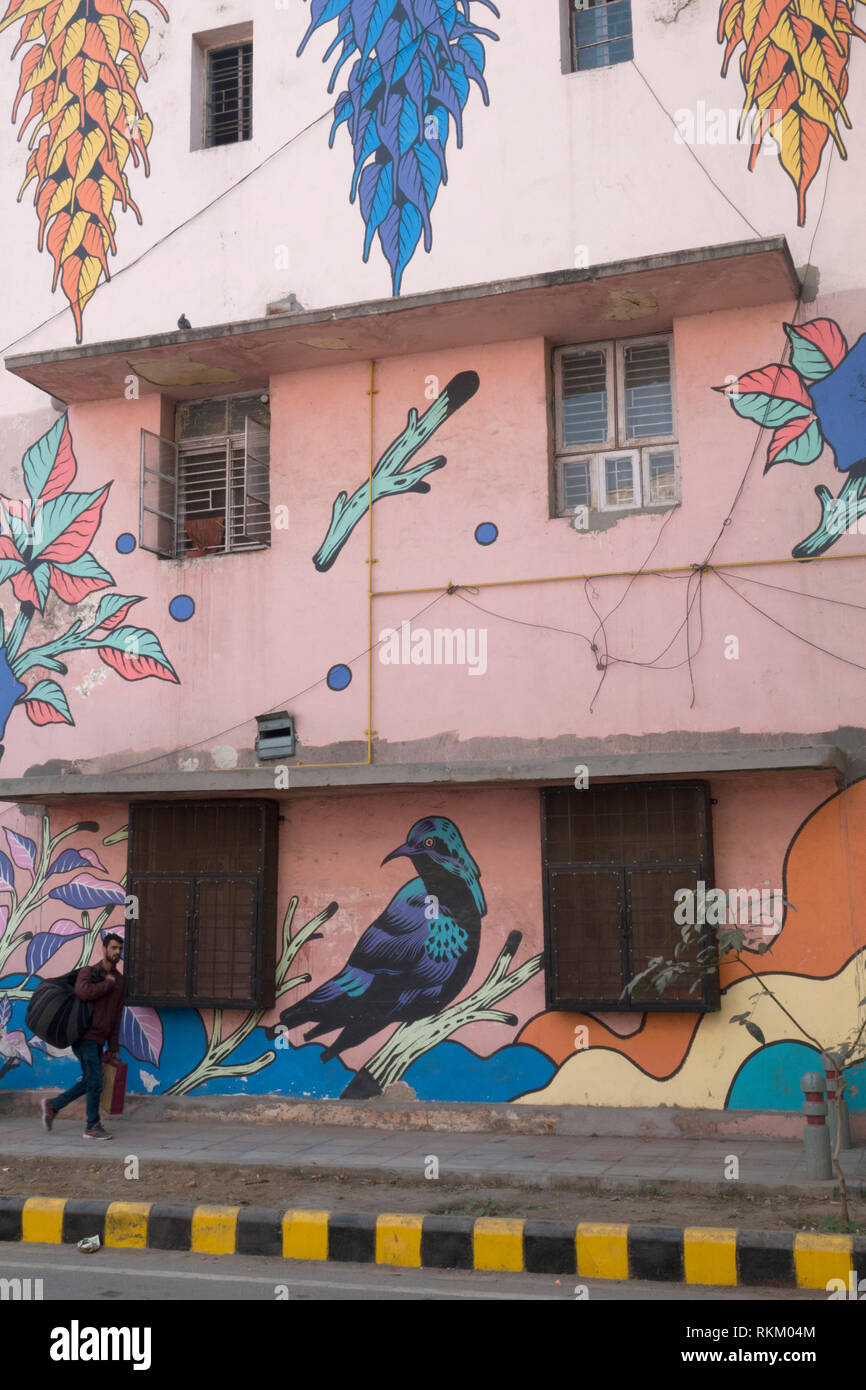 Un homme passe devant une peinture murale d'artistes brésiliens Bicicleta Sem Freio, dans la colonie de Lodhi, New Delhi, Inde Banque D'Images