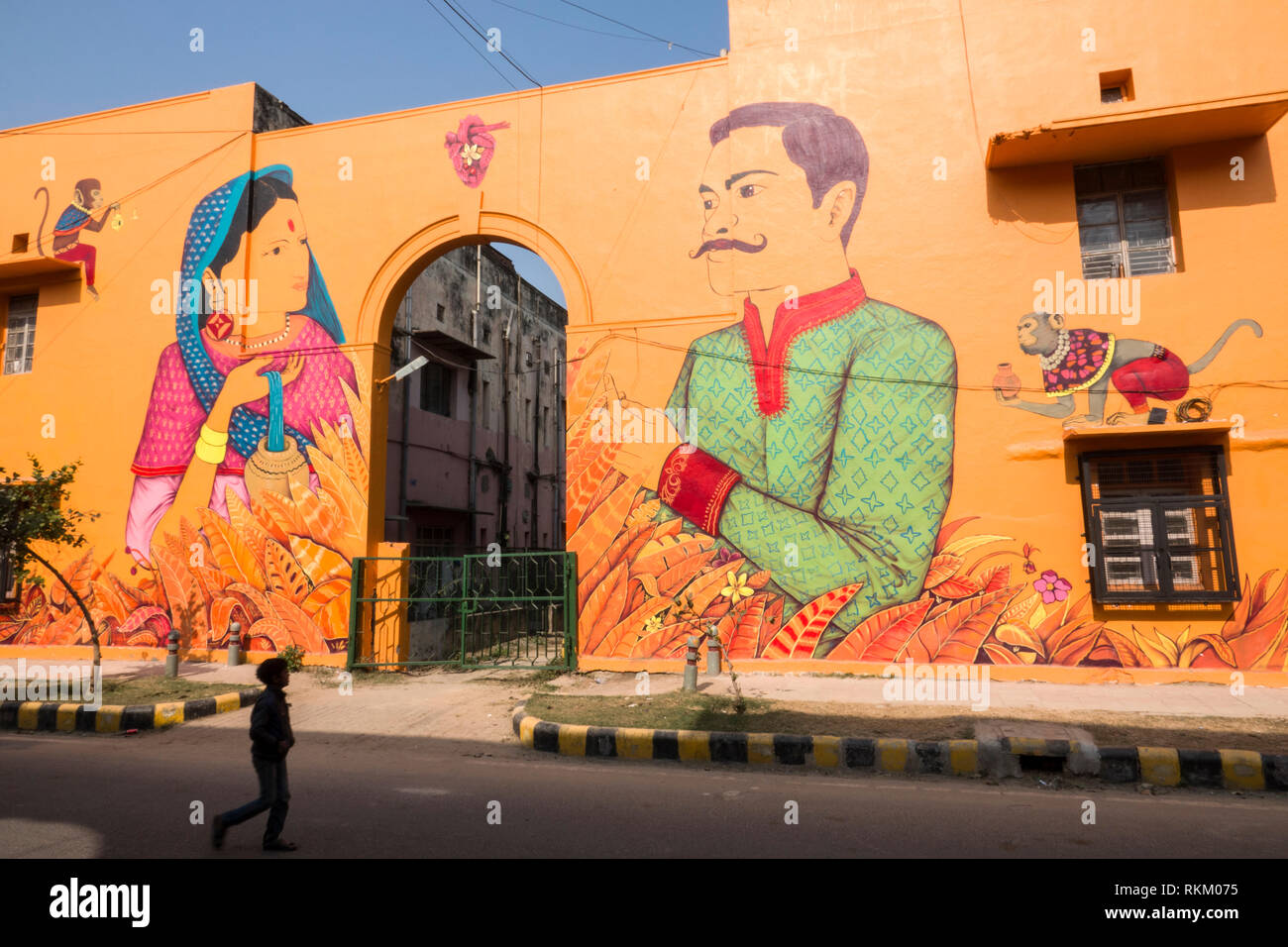 Jeune Indien passe devant une fresque murale peinte par l'artiste mexicain Saner dans Lodhi colony, New Delhi, Inde Banque D'Images