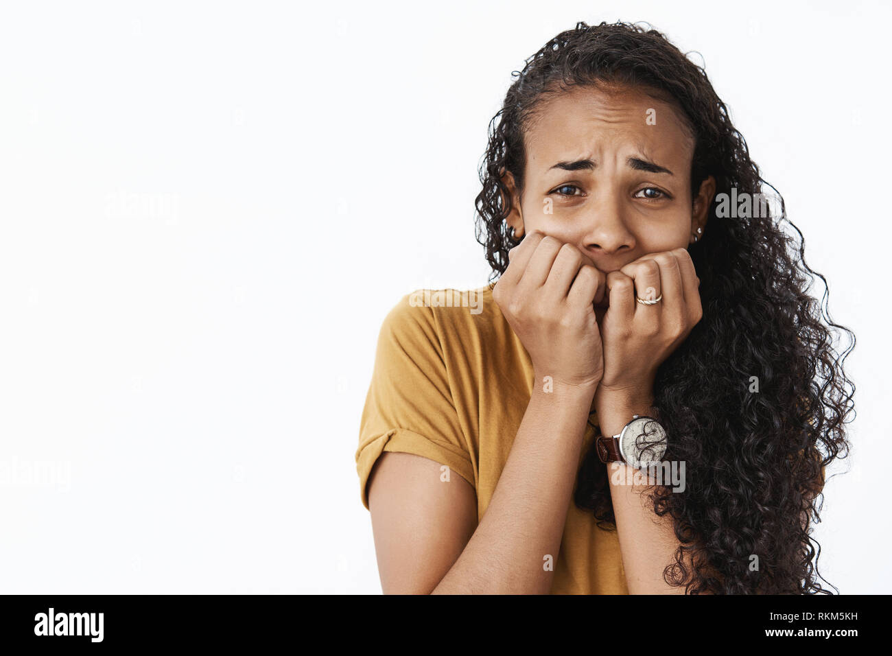 Close-up shot de peur peur timide african american woman fronçant trembing de peur que voir spooky scène de film, tenant les ongles sur la bouche Banque D'Images