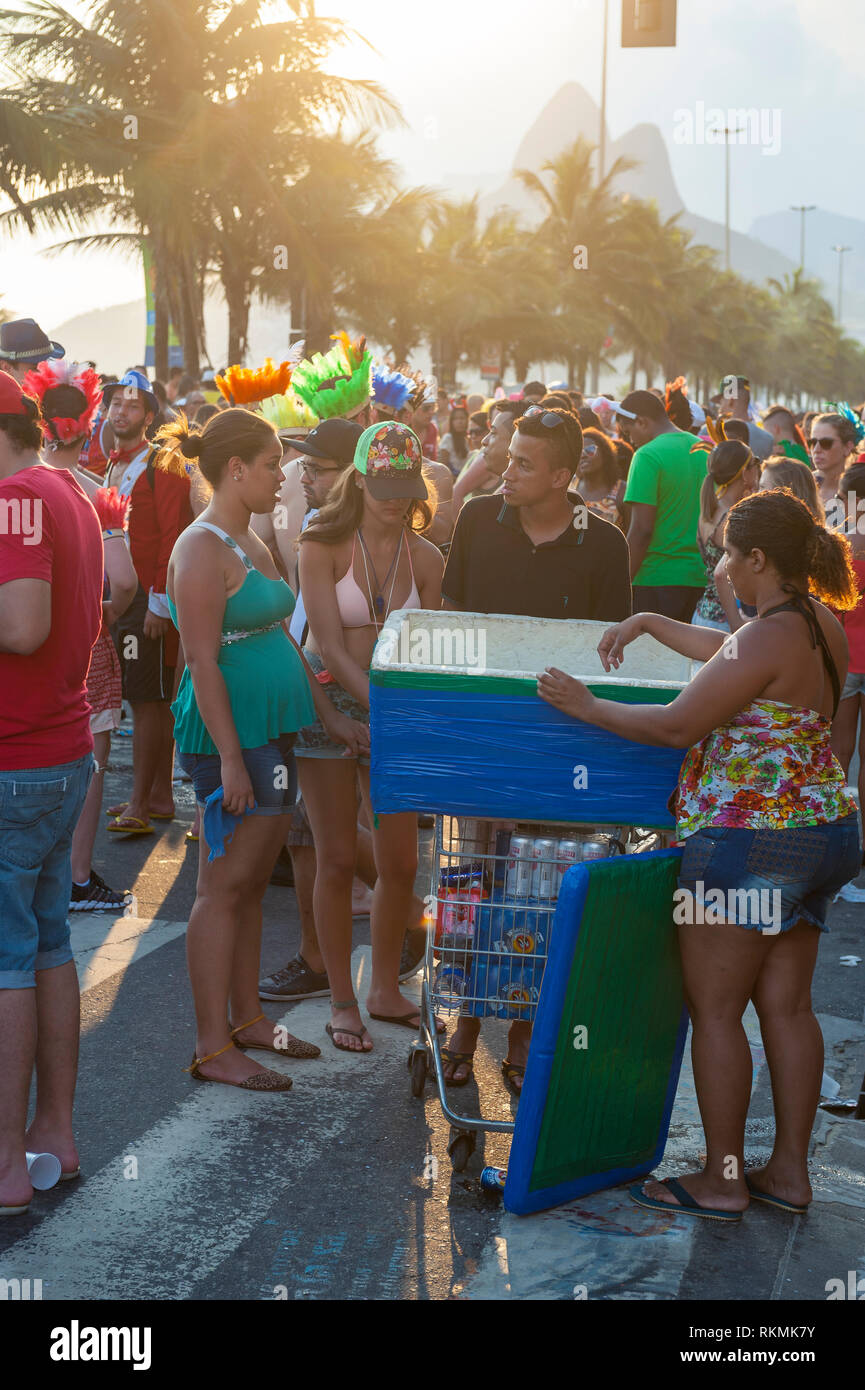 RIO DE JANEIRO - le 20 janvier 2015 : les vendeurs de rue brésilien avec un refroidisseur de bière de vendre aux jeunes à un carnaval fête de rue à Ipanema. Banque D'Images