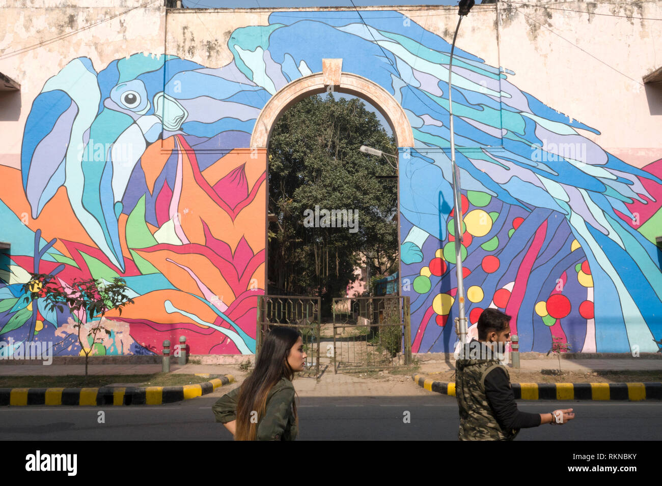 Un couple devant une peinture murale de la rue d'un Calao Pie Oriental par Renato Reno de Lodhi Colony, New Delhi, Inde Banque D'Images