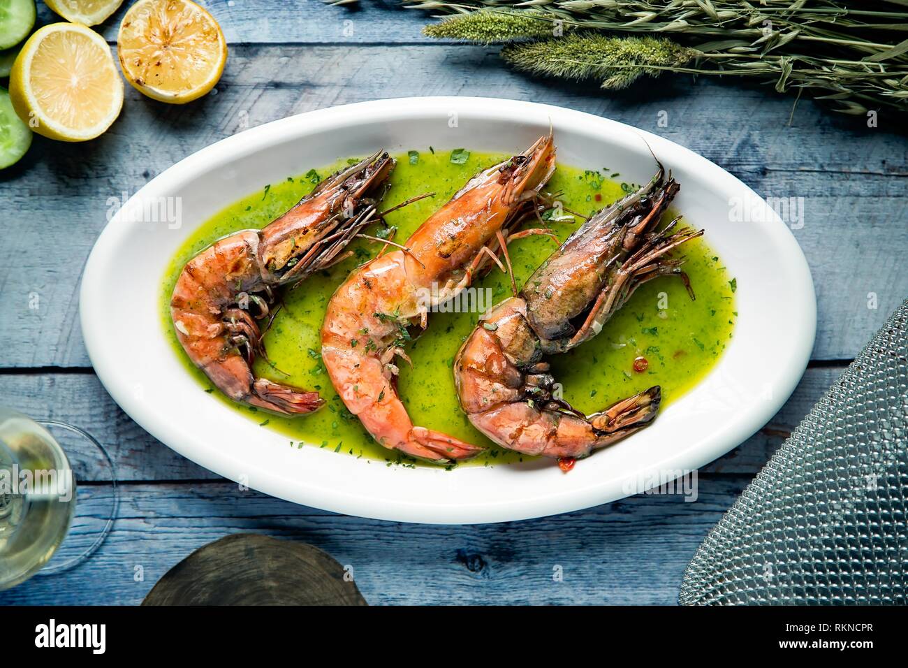 Flat Lay image d'une assiette de crevettes tigrées cuites servi dans une sauce aux herbes avec du citron Banque D'Images