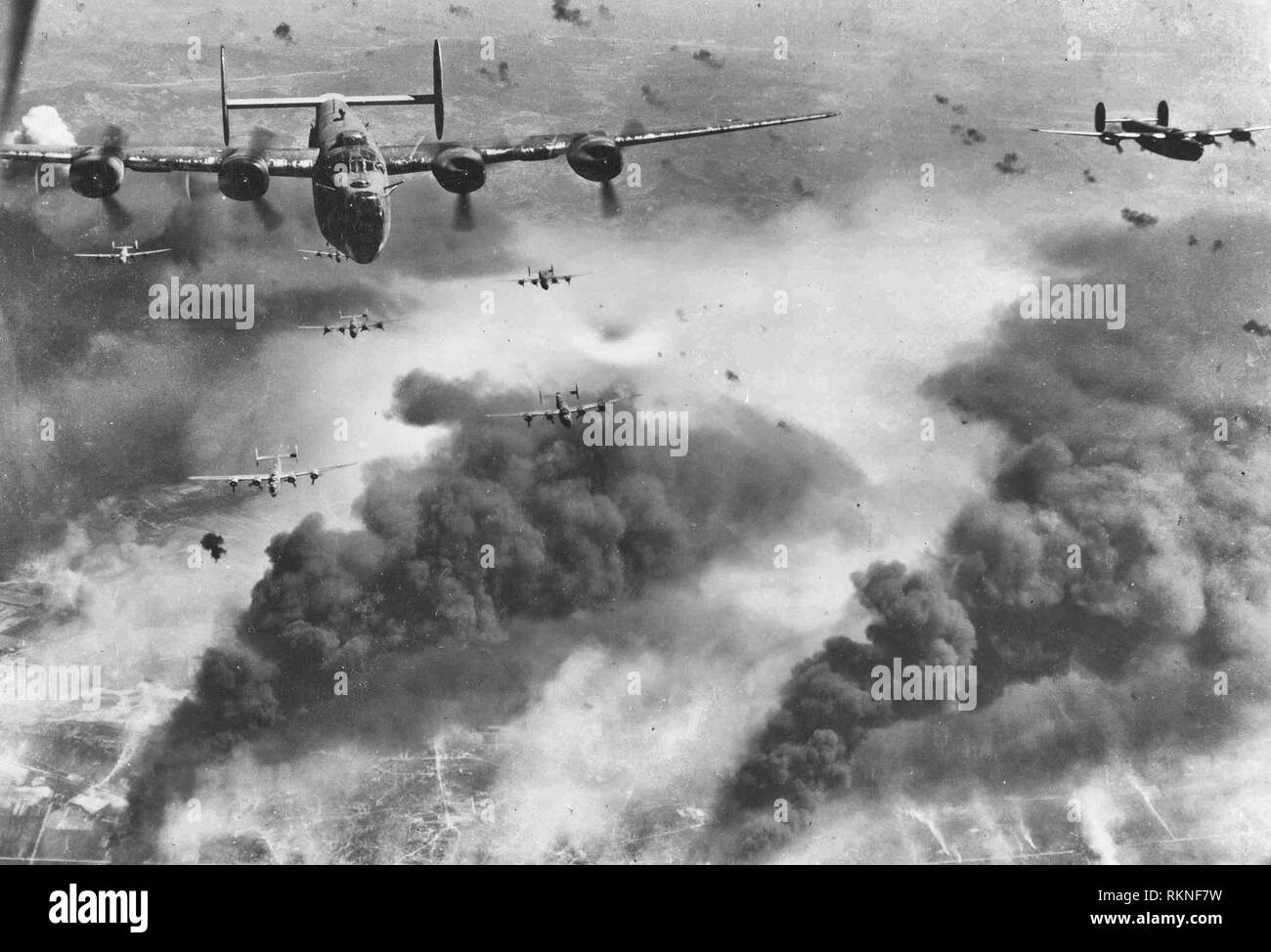 B-24 Liberator par flak et à la destruction créée par les vagues précédentes de bombardiers, ces 15e Air Force B-24s quitter Ploesti, en Roumanie, après l'un de la longue série d'attaques contre les cibles d'huile n° 1 en Europe. Le 1er août 1943 Banque D'Images